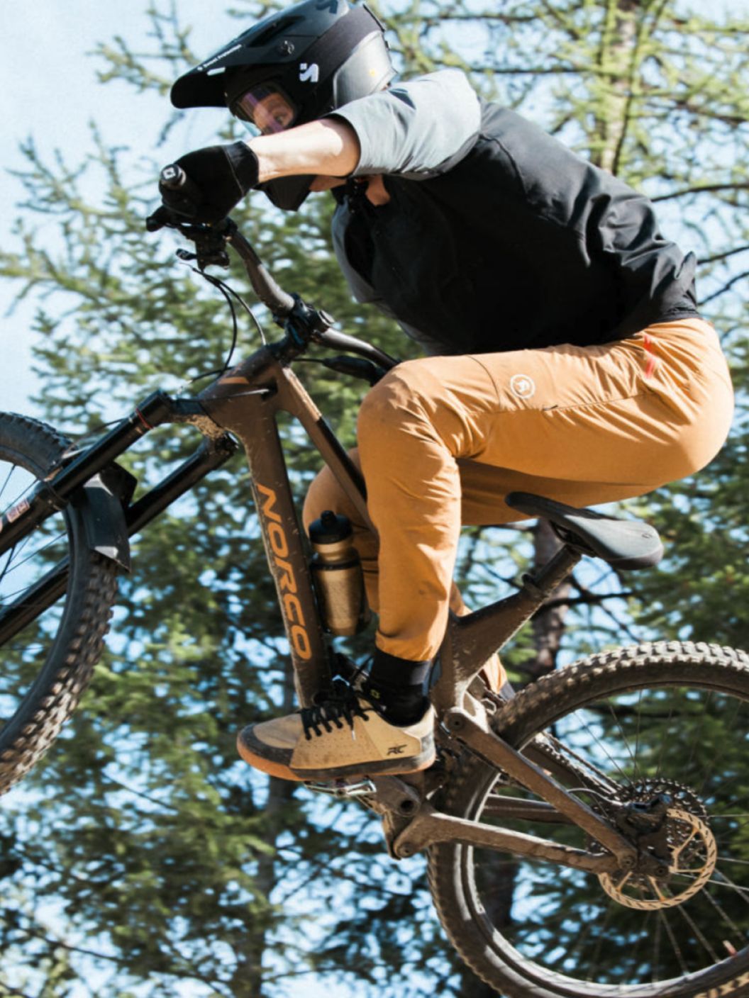 A bike rider catches air and prepares to land. 